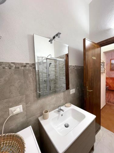 a bathroom with a sink and a mirror at Villetta La Risacca - fronte mare - seafront in Costa Paradiso
