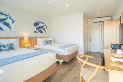 a hotel room with two beds and a desk at Gilbert's Resort in Key Largo