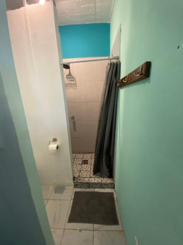 a bathroom with a shower and a tiled floor at Lote 44 Guesthouse in El Zonte
