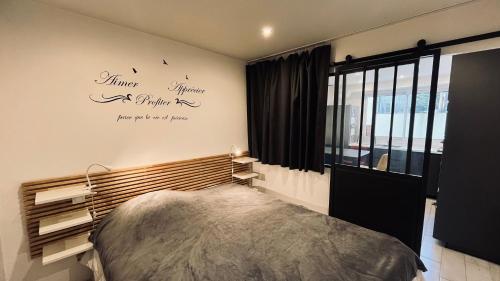 - une chambre avec un lit et un bureau sur le mur dans l'établissement Appart océan et pinède, à Saint-Jean-de-Monts