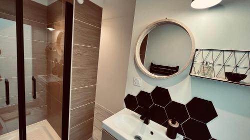 une salle de bain avec un lavabo et un miroir dans l'établissement Appart océan et pinède, à Saint-Jean-de-Monts