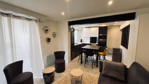 un salon avec une table et des chaises et une cuisine dans l'établissement Appart océan et pinède, à Saint-Jean-de-Monts