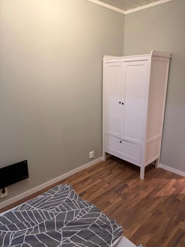 a bedroom with a bed and a white cabinet at Apartment close to the city center in Sandefjord