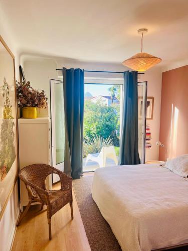 une chambre avec un lit et une grande fenêtre dans l'établissement Belle maison grand jardin proche Côte des Basques, à Biarritz