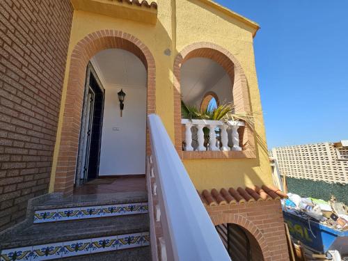 a house with a staircase leading up to a door at Vive la playa a lo grande!!! in Cullera