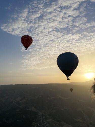 two hot air balloons flying in the sky at Manzara Camping in Pamukkale