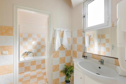a white bathroom with a sink and a shower at Sofi Hotel in Neokhórion