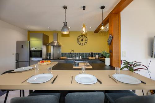 une cuisine avec une grande table et 4 plaques blanches dans l'établissement La Marine, maison en plein cœur de Wimereux, à Wimereux