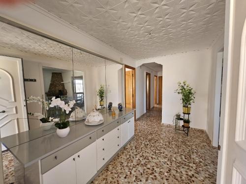 a bathroom with a vanity with a mirror and flowers at Vive la playa a lo grande!!! in Cullera