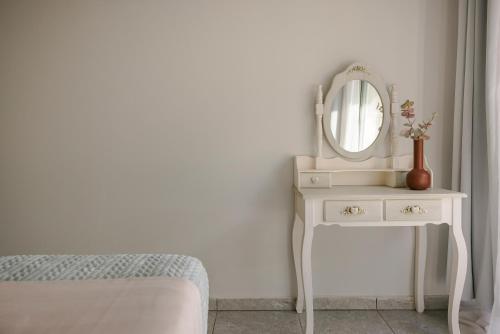 a white dressing table with a mirror and a bed at Sofi Hotel in Neokhórion