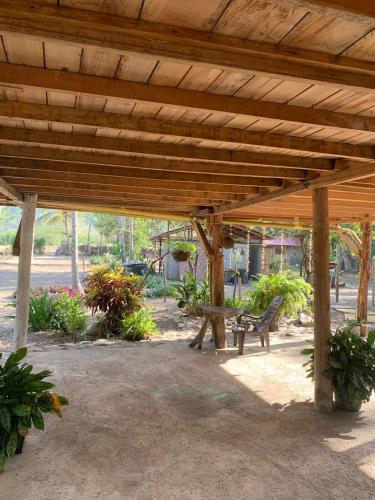 a wooden pavilion with a bench in a park at Antigua "Hostel Playero" in Palomino