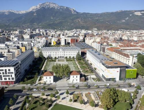 une vue aérienne sur une ville avec des bâtiments et une montagne dans l'établissement Appartement COSY 120m2 Grenoble/Caserne de bonne, à Grenoble