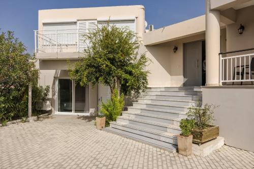 a white house with stairs in front of it at Sofi Hotel in Neokhórion
