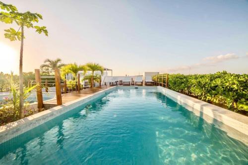 una piscina con acqua azzurra e palme di Oceanview Pool Near Av 5th Beach 6 Guest Fast WiFi a Playa del Carmen