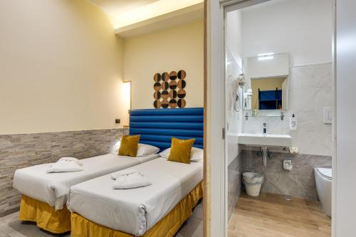 a hotel room with two beds and a bathroom at Seven in Rome