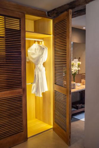 a closet with a white dress on a rack at La Maria Hotel Boutique in Chacras de Coria