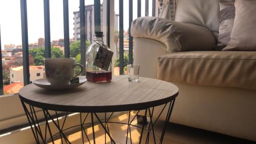 a coffee table with a bottle of wine and a glass at Olivia's Place in Funchal