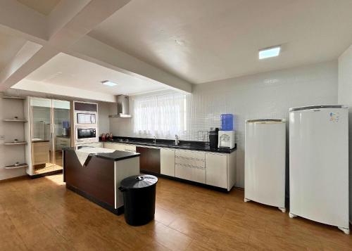 a large kitchen with white appliances in a room at F.Santos Beach House in Navegantes