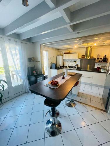 une cuisine avec une table au milieu dans l'établissement Warm house close to all amenities, à Tarnos