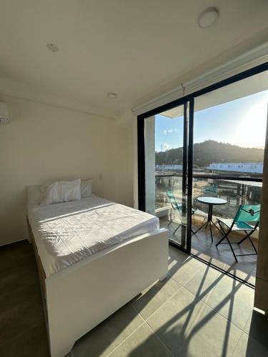 Un dormitorio con una cama y un balcón con vistas. en Apartamento 308 Coralina suites, en Santa Marta