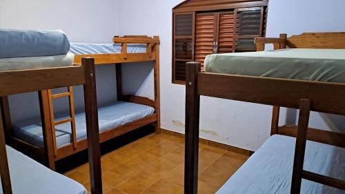 a room with two bunk beds and a chair at Casa de Campo em Biritiba Mirim in Biritiba-Mirim