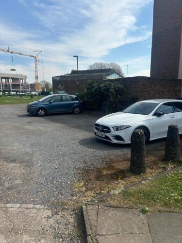 two cars parked in a parking lot next to a building at Cavendish house in Strawberry Hill