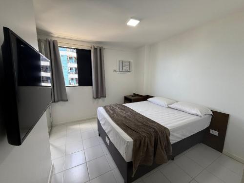 a bedroom with a bed and a flat screen tv at Edificio Neo Apto 401 in Maceió