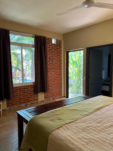 a bedroom with a large bed and two windows at OCEAN OASIS HOTEL - adult only, four casitas boutique resort in Playa Agua Blanca