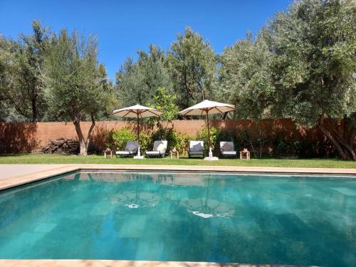 une piscine avec chaises et parasols dans une cour dans l'établissement Villa Azuréa with pool 4 bedrooms and 2 living rooms, à Ourika