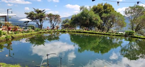 a pool of water with trees and mountains in the background at Suite 1 El Palco del Neusa in Cogua