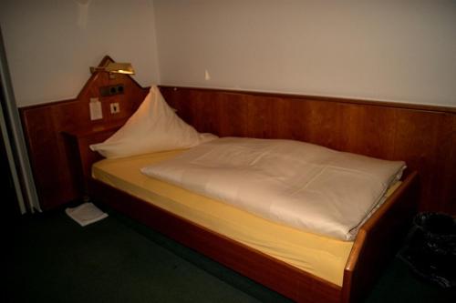 a bed in a room with a wooden head board at Hotel Restaurant Bären in Freudenstadt