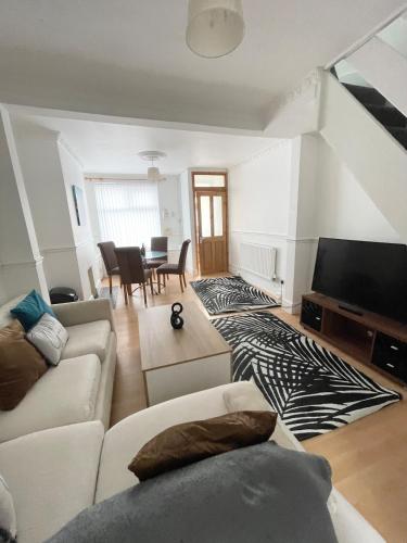 a living room with a couch and a tv at Cute two bedroom house with free street parking in Liverpool