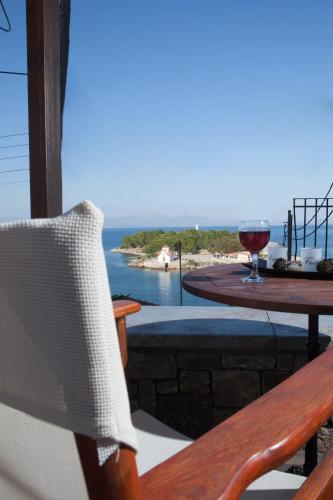 a glass of wine on a table with a view of the ocean at Laconian Blue Residence in Gythio
