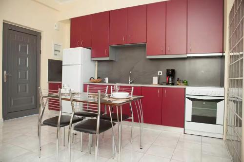 a kitchen with red cabinets and a table and chairs at Laconian Blue Residence in Gythio