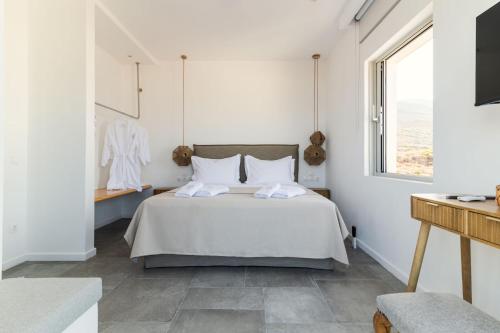a white bedroom with a bed and a window at Makrikythera Luxury Sea House in Kýthira