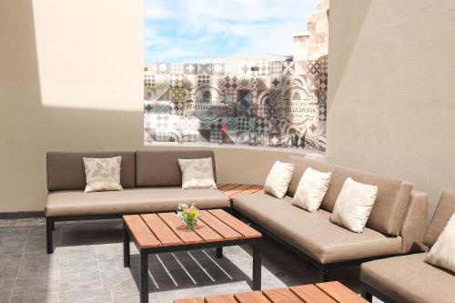 a living room with two couches and a coffee table at Hotel Hacienda Aguacaliente in Tijuana