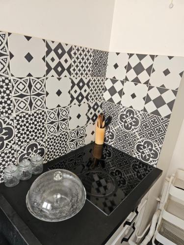 a kitchen counter with a sink and black and white tiles at Appart proches saint Lazare la défense in Argenteuil