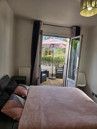 a bedroom with a bed and a patio with an umbrella at Appart proches saint Lazare la défense in Argenteuil