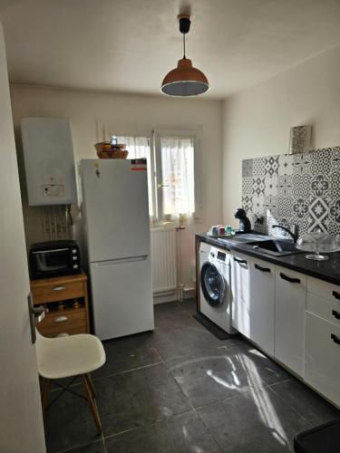 une cuisine avec un réfrigérateur et une machine à laver dans l'établissement Appart proches saint Lazare la défense, à Argenteuil