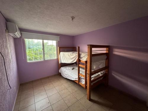 a bedroom with two bunk beds and a window at Casa en Acapulco los tulipanes in Acapulco