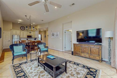 a living room with a television and a dining room at Cypress Point Condominiums at Craft Farms #306B in Gulf Shores