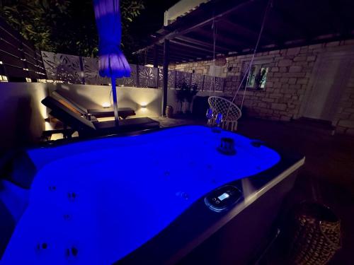 a blue bath tub in a dark room at La vie est belle Luxury Residence With Jacuzzi '2' in Pounda