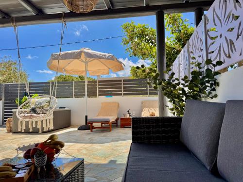 a patio with a couch and an umbrella at La vie est belle Luxury Residence With Jacuzzi '2' in Pounda