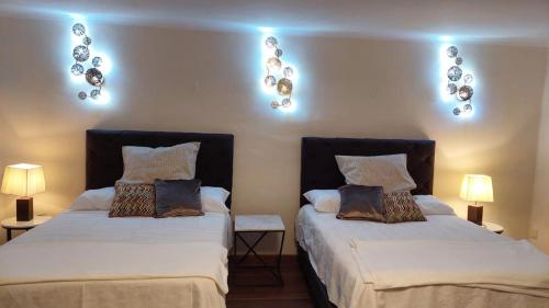 two beds sitting next to each other in a room at Apartamento en Centro Histórico de Sucre in Sucre