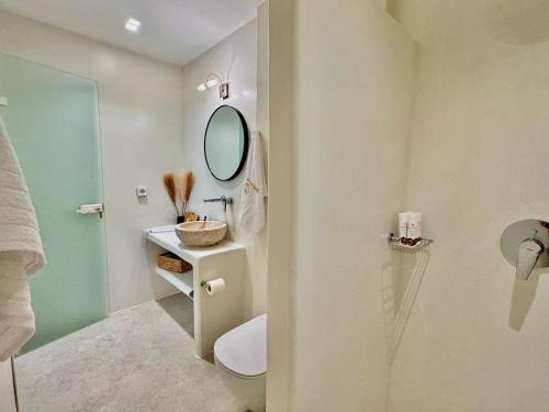 a bathroom with a toilet and a sink and a mirror at La vie est belle Luxury Residence With Jacuzzi '2' in Pounda