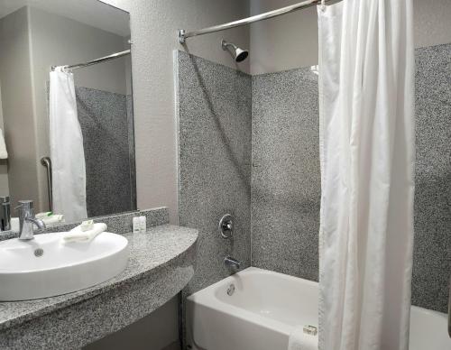 a bathroom with a sink and a tub and a shower at Baymont by Wyndham San Antonio Airport in San Antonio