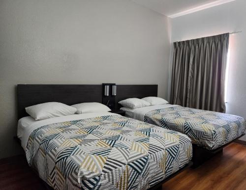 a hotel room with two beds and a window at Baymont by Wyndham San Antonio Airport in San Antonio