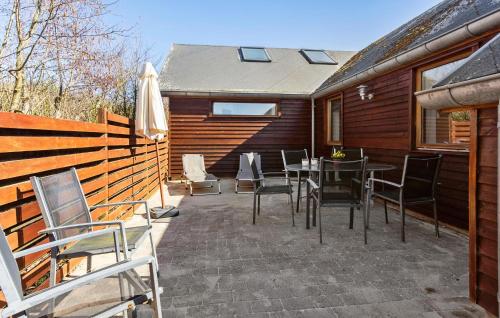 a patio with chairs and a table and an umbrella at Amazing Home In Vinderup With Sauna in Vinderup