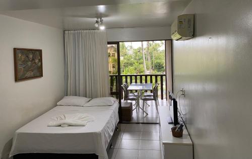 a bedroom with a bed and a balcony with a table at Nannai Residence - Muro Alto - Porto de Galinhas in Porto De Galinhas
