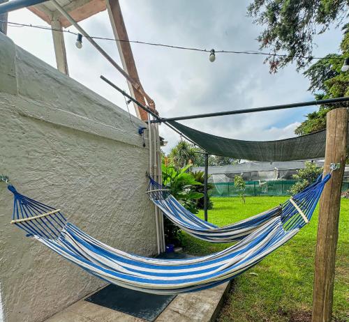 un hamac bleu fixé sur le côté de la maison dans l'établissement Jardin Prana, à Belén de Escobar